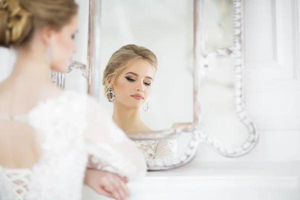 Junge schöne blonde Frau posiert in einem Hochzeitskleid — Stockfoto