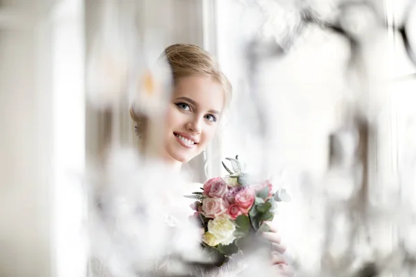 Mulher loira bonita com buquê posando em um vestido de noiva — Fotografia de Stock