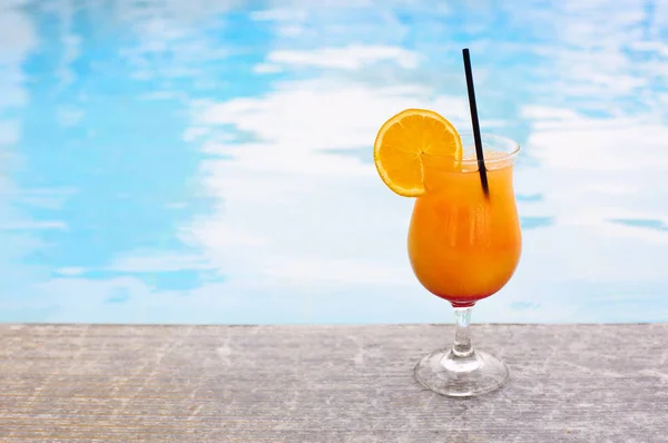 Glass of tropical cocktail on poolside — Stock Photo, Image