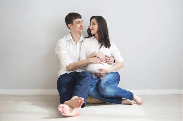 Zwangere vrouw en jonge man samen binnenshuis — Stockfoto