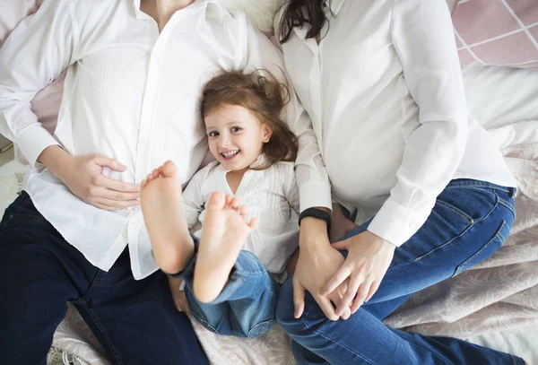 Glad gravid kvinna med sin man och lilla dotter — Stockfoto