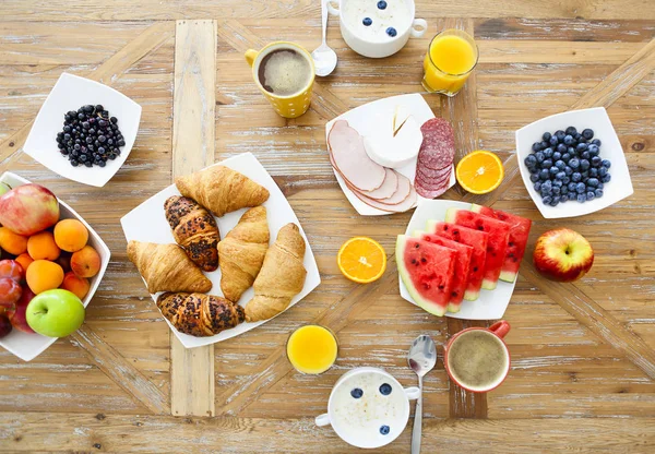 Meyveli kahve, mısır gevreği ve ahşap masa üzerinde kruvasan. — Stok fotoğraf
