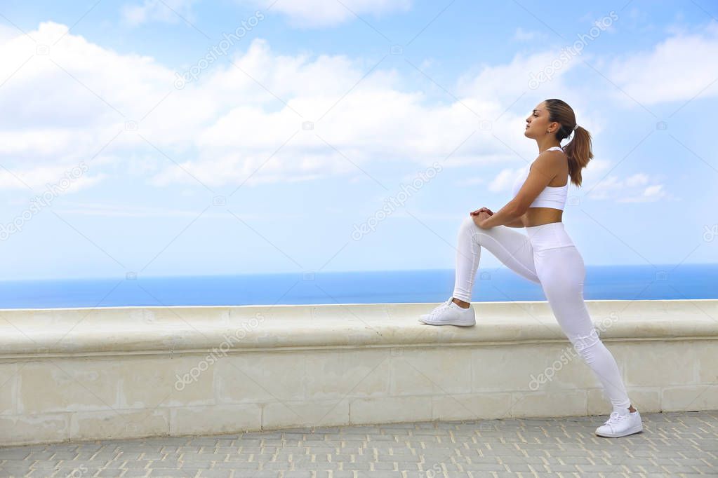 Beautiful woman making stretching exercises in the beach 