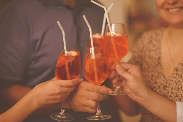Group of friends cheers with aperol spritz in restaurant — Stock Photo, Image