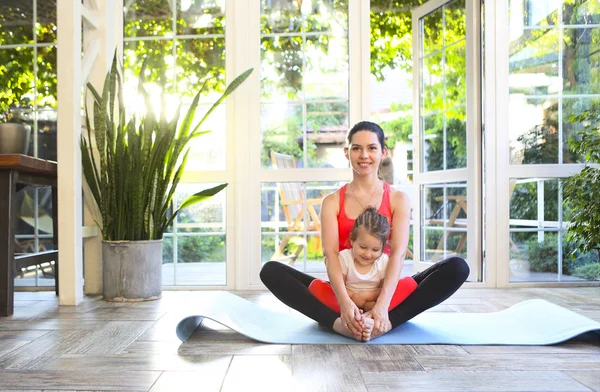 Genç esmer kadın ve küçük kızı spor üniformalı. — Stok fotoğraf