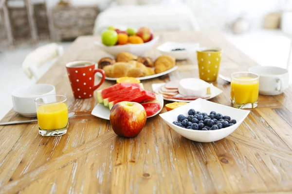 Café con fruta, cereal y croissant sobre fondo de mesa de madera —  Fotos de Stock