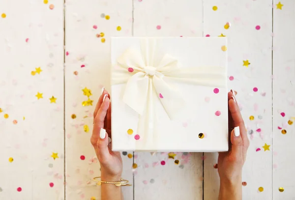 Female hands with a white manicure holding gift box for the Chri — Stock Photo, Image