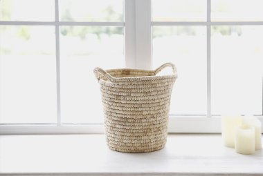 Sepet ve mumlar pencerenin önünde içeri ışık saçıyor.