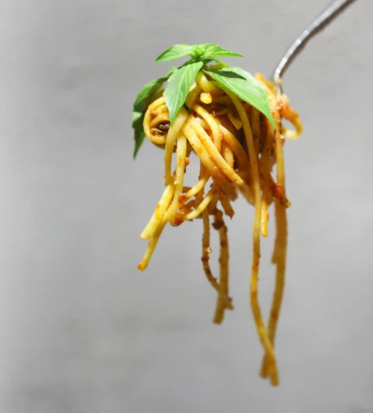 Cubierta de salsa boloñesa de espaguetis enrollada en tenedor con albahaca — Foto de Stock