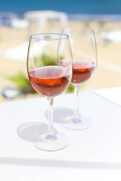 Дві склянки трояндового вина проти блакитної води і моря — стокове фото