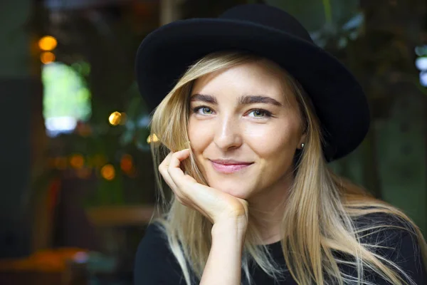 Attractive cute caucasian girl in black tshirt and black hat — Stock Photo, Image