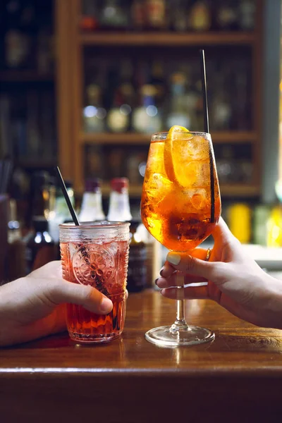 Donna e uomo che alzano un bicchiere di coktail nel bar — Foto Stock