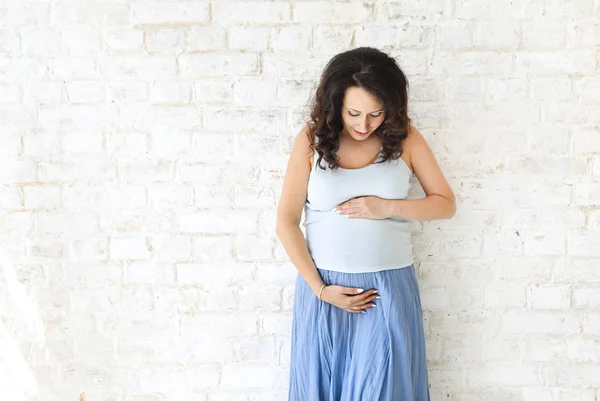 Zwanger vrouw aanraken van haar buik met handen — Stockfoto