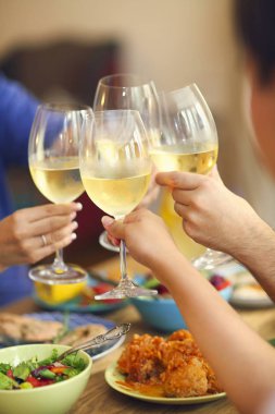 Beyaz şarapla tezahürat yapan bir grup insanın elleri.