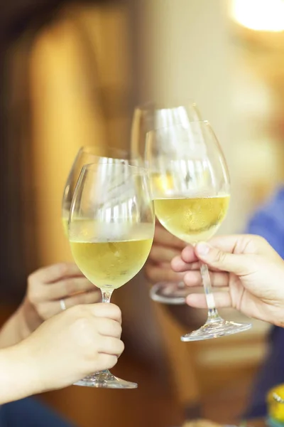 People cheering with white wine and rising glasses on celebratio — Stock Photo, Image