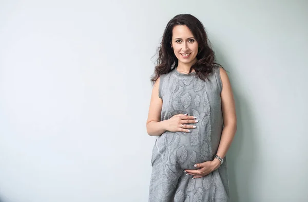 Zwanger vrouw aanraken van haar buik met handen — Stockfoto