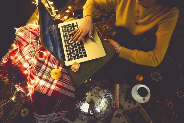 Beautiful young woman shopping online on laptop in cozy Christma — Stock Photo, Image