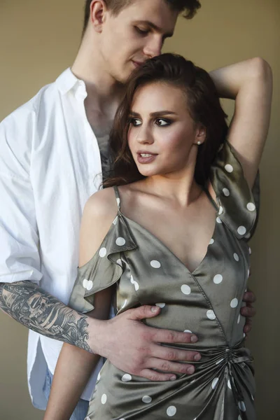 Татуированный стильный парень обнимает свою красивую девушку — стоковое фото