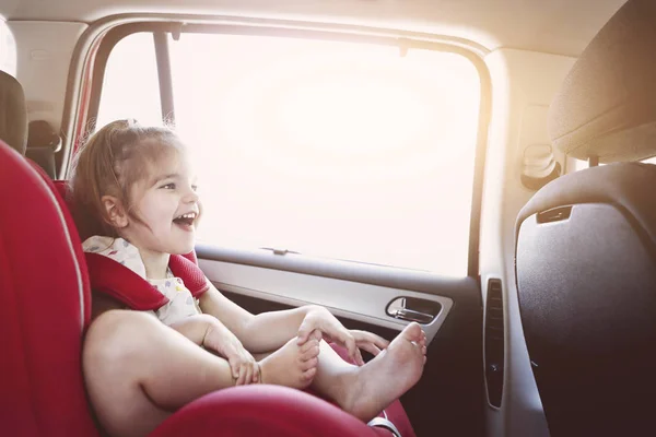 Cute little girl in car safety seat smiling — Stock Photo, Image