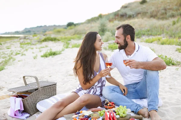 Pár popíjení růžového vína na pikniku na pláži — Stock fotografie