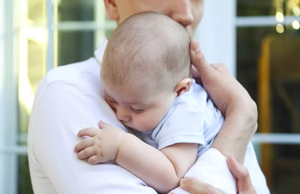 Portrait of young man holding adorable sleeping baby in his hand — 스톡 사진