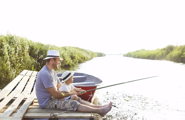 Padre con piccolo figlio che pesca sulla riva del fiume — Foto Stock