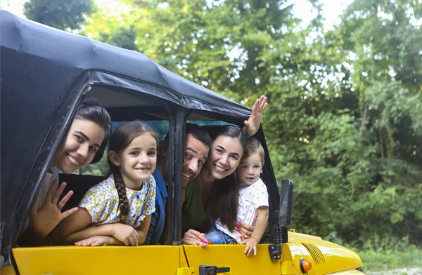 Feliz familia sonriente con niños en el coche con el río de montaña ba —  Fotos de Stock