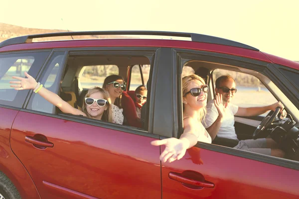 Feliz familia sonriente con hijas en el coche con fondo de mar —  Fotos de Stock