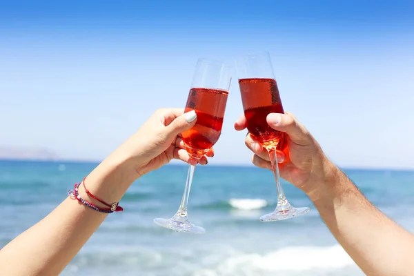 Mãos de casal desfrutando de copos de champanhe na praia tropical — Fotografia de Stock
