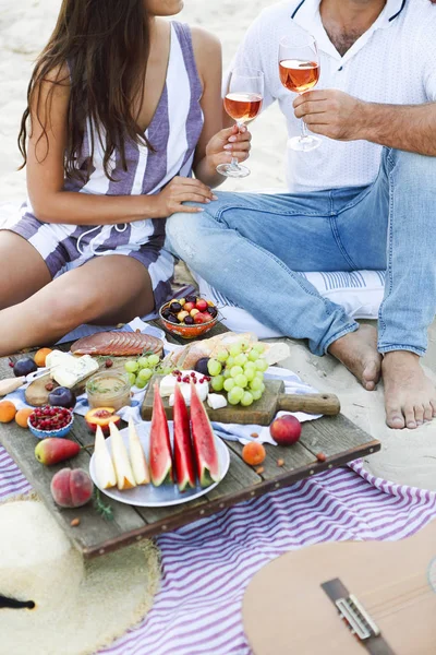 Par som dricker rosévin på picknick på stranden — Stockfoto