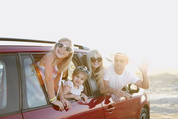 Heureuse famille souriante avec des filles dans la voiture avec backgrou mer — Photo