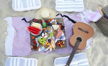 Boho tarzında gün batımında sahilde piknik