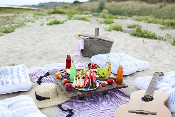 Picnic on the beach at sunset in the style of boho