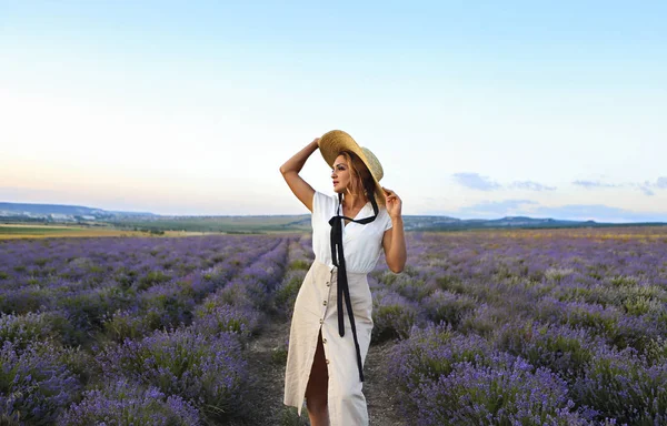 Hermosa mujer en sombrero de paja en el campo de lavanda violeta —  Fotos de Stock