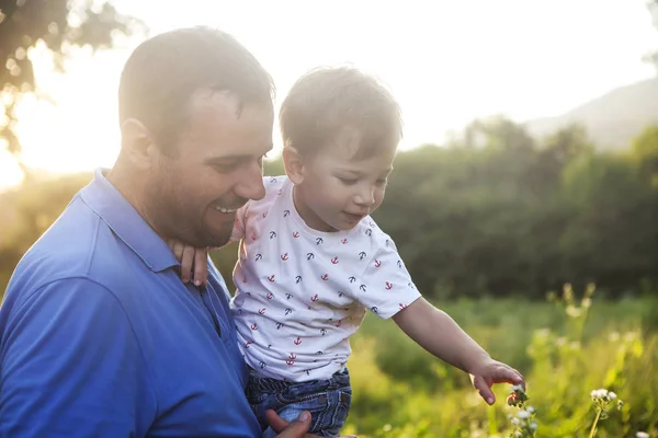 Portret van een jonge man die een schattige slapende baby in zijn hand houdt — Stockfoto