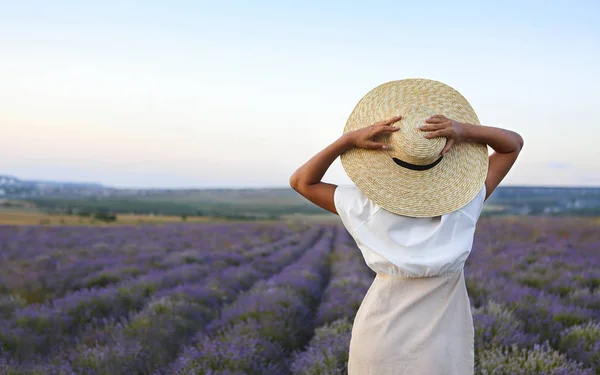 Bella donna in cappello di paglia in campo viola lavanda — Foto Stock