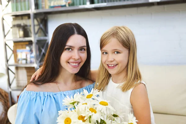 Kleines Mädchen schenkt ihrer Mutter einen Strauß schöner Blumen — Stockfoto
