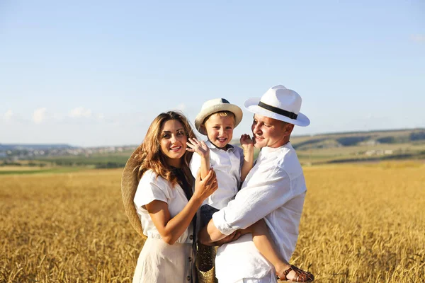 Familia feliz con hijo feliz en el campo de atardecer de verano — Foto de Stock