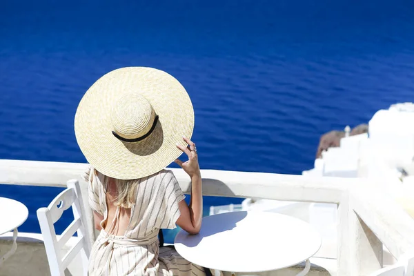 Jeune femme en robe blanche et chapeau de paille, marchant dans la ville — Photo