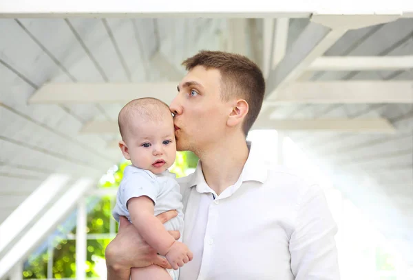 Portrait of young man holding adorable baby son in his hands — Stok fotoğraf