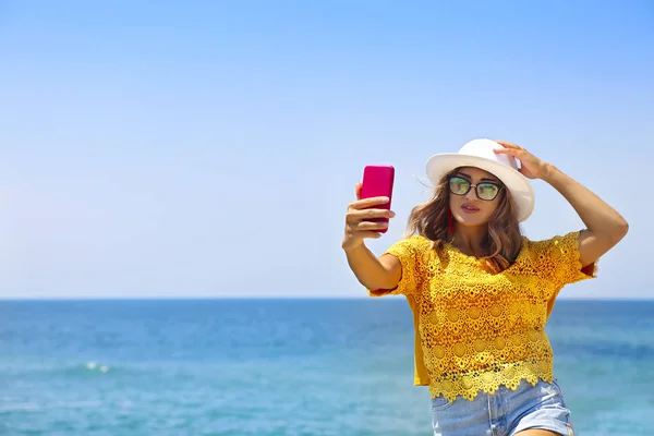 Young happy blond woman taking selfie portrait with mobile phone — Stok fotoğraf