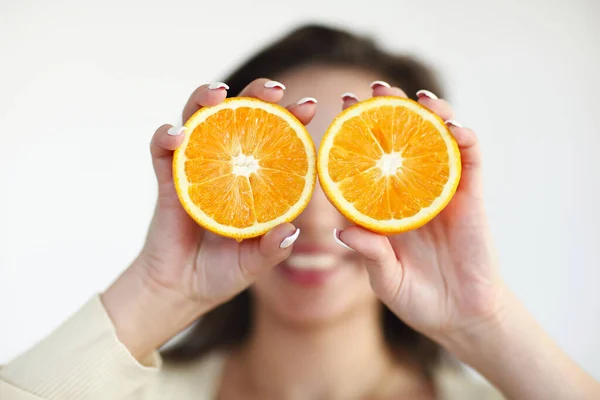 Menina segurando laranja madura isolado no fundo de luz — Fotografia de Stock