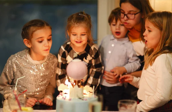 Group of joyful little kids celebrating birthday party and blowi — Stock Photo, Image