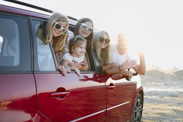 Šťastná usměvavá rodina s dcerami v autě s mořským pozadím — Stock fotografie