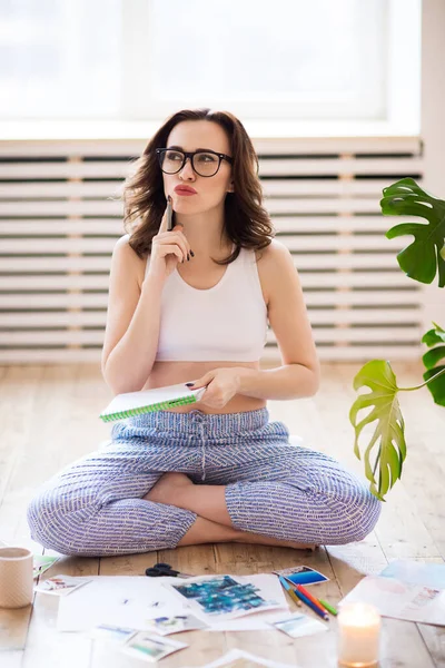 Mujer morena joven creando su mapa de deseos Feng Shui utilizando tijera — Foto de Stock