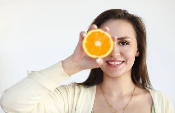 Menina segurando laranja madura isolado no fundo de luz — Fotografia de Stock