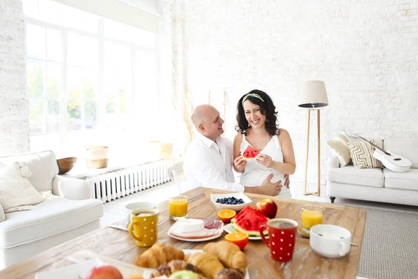 Amar tierna pareja embarazada en la mesa con el desayuno — Foto de Stock