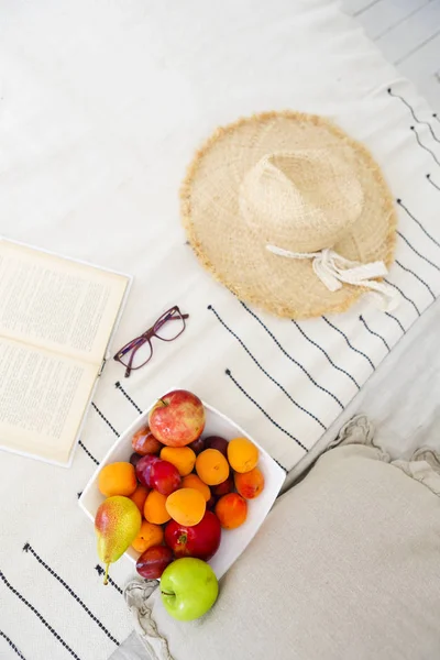 Piatto di frutta assortimento e libro sul letto — Foto Stock