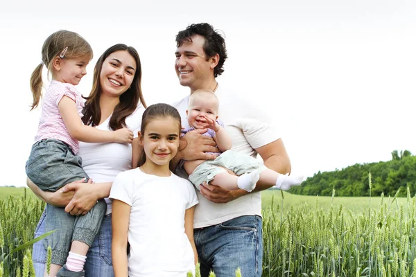 Família feliz alegre no campo de trigo — Fotografia de Stock