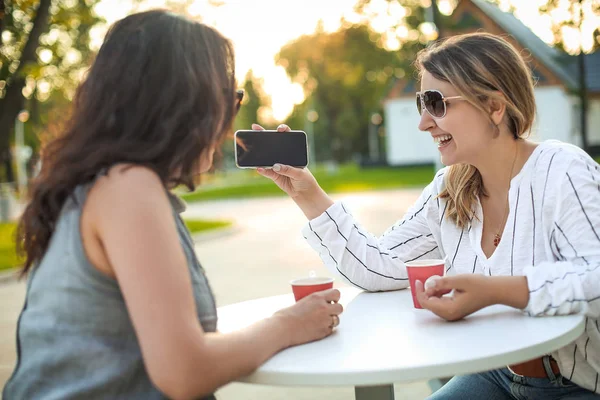 Mujeres adultas alegres con café y teléfono móvil en la calle —  Fotos de Stock